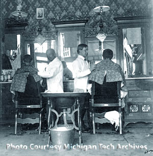 Interior of a barber shop with two barbers at work